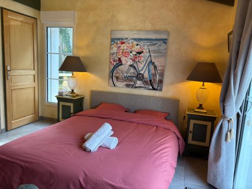 a bedroom with a red bed with two towels on it at La maison bleue in Dolus-d'Oléron