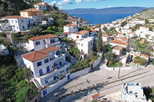 a village on a hill with the ocean in the background at Aori Guest House II in Hydra