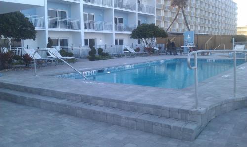 a swimming pool in front of a building at Lotus Boutique Inn and Suites in Ormond Beach