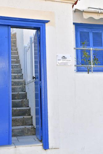 a blue door and stairs in a white building at Aori Guest House II in Hydra
