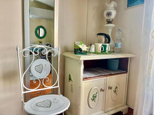 une petite armoire dans une maison de poupées avec une chaise dans l'établissement L'Oasi Felice, à Tropea