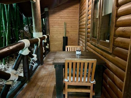 a wooden table and chair on the porch of a cabin at Platon Ecolodge in Santa Cruz de Barahona
