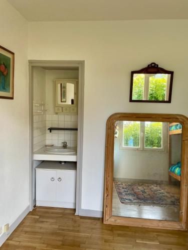 une salle de bain avec un miroir et un lavabo dans l'établissement Maison aux camélias, à Locquénolé