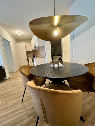 a dining room table with chairs and aendant light at COHO City Apartments mit hauseigener Tiefgarage in Vienna