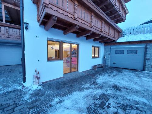 a house with a garage and a driveway at Dolomiten Home in Villnoss