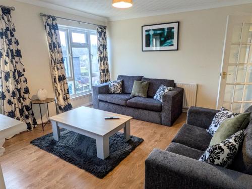 a living room with two couches and a coffee table at Theatre Severn Town House, Parking & Quarry Views in Shrewsbury
