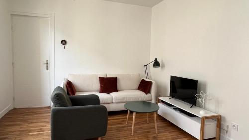 un salon avec un canapé blanc et une télévision dans l'établissement Charmant 2 pièces calme proche Paris, à Cachan