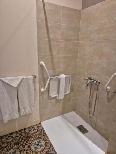 a bathroom with a tub and a shower with towels at Hotel Saint Jean in Chalon-sur-Saône