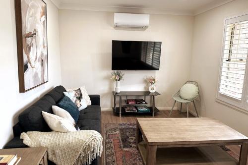 a living room with a couch and a tv at 3BR house with parking & AC, 15 mins walk to wharf in Greenwell Point