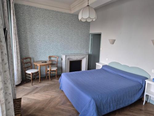 a bedroom with a bed and a table and chairs at Hotel Saint Jean in Chalon-sur-Saône