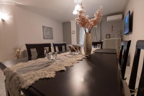 a dining room table with a vase with flowers in it at Vicky 's Luxury House in Nafpaktos