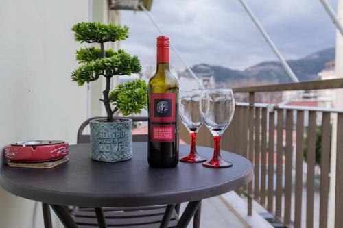 a bottle of wine and two wine glasses on a table at Vicky 's Luxury House in Nafpaktos