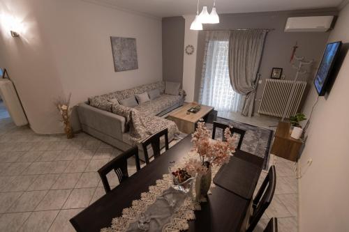 a living room with a couch and a table with chairs at Vicky 's Luxury House in Nafpaktos
