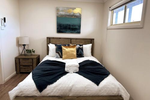 a bedroom with a large bed with pillows at 3BR house with parking & AC, 15 mins walk to wharf in Greenwell Point