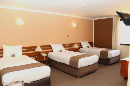 a hotel room with two beds and a television at DM Hoteles Arequipa in Arequipa