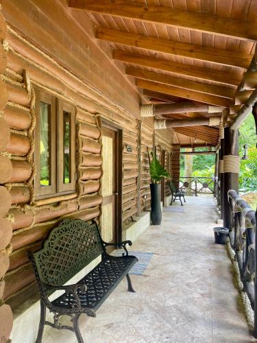 a bench sitting on the porch of a log cabin at Platon Ecolodge in Santa Cruz de Barahona