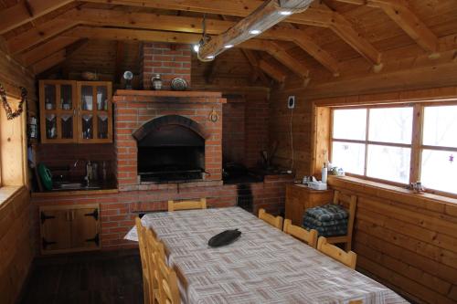 a room with a table and a brick fireplace at Odăile Craiului in Şirnea