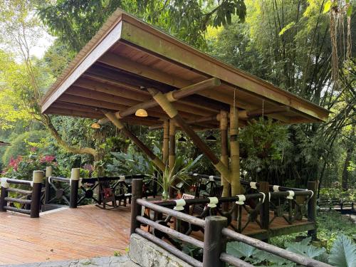 a wooden deck with a pavilion in a garden at Platon Ecolodge in Santa Cruz de Barahona