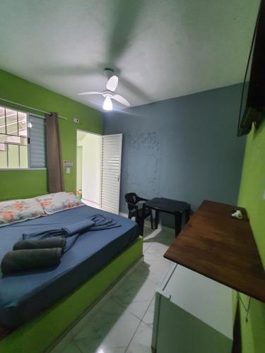 ein Schlafzimmer mit einem Bett und einem Tisch darin in der Unterkunft Pousada Maranata in Guarujá