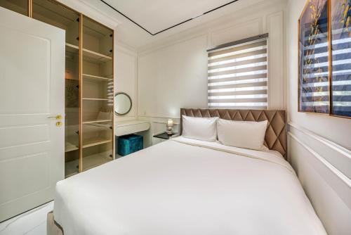 a white bedroom with a large bed and a window at DT Retreat - Biệt thự nguyên căn - 3 Phòng ngủ - Novaworld Phan Thiết in Phan Thiet