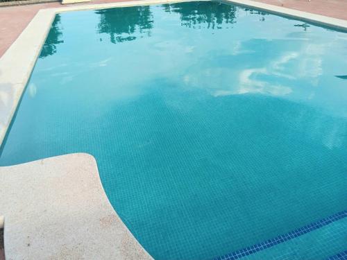 a large swimming pool with blue water at Orange Room Your refuge of tranquility and privacy in Alzira