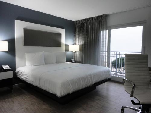 una camera con un grande letto e un balcone di Lotus Boutique Inn and Suites a Ormond Beach