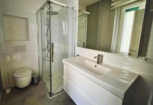 Un baño con lavabo, ducha e inodoro. en SUNSET HOUSe AIR CON Large Balcony, Unbeatable view and Peace, en Perledo