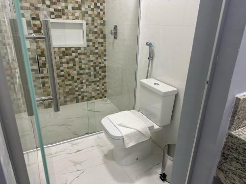 a bathroom with a toilet and a glass shower at Hotel Premier in Belo Horizonte