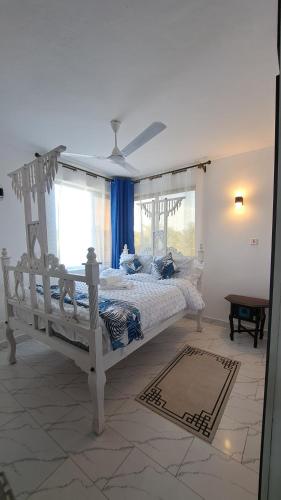 a bedroom with a white bed and a window at Casa Marabella C3 in Diani Beach