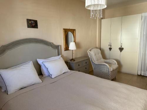 een slaapkamer met een groot bed en een stoel bij Casa Vivien in Cotillo