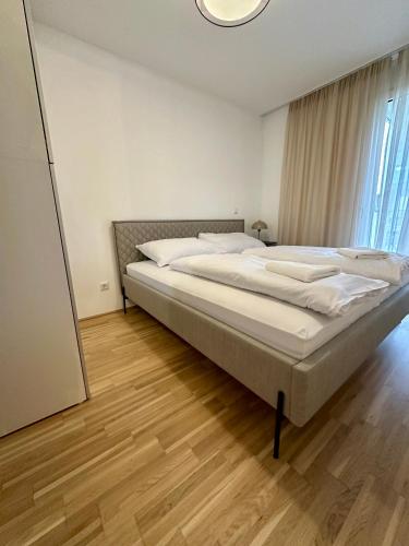 a large bed in a bedroom with a mirror at COHO City Apartments mit hauseigener Tiefgarage in Vienna