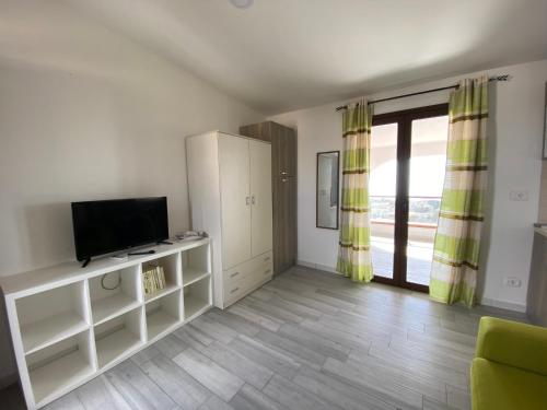 a living room with a television and a sliding glass door at Nora's Flats in Triscina
