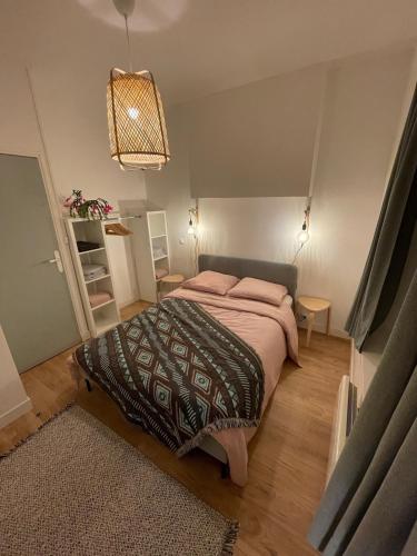 une chambre avec un grand lit avec des oreillers roses dans l'établissement Marine 1, à Cherbourg en Cotentin