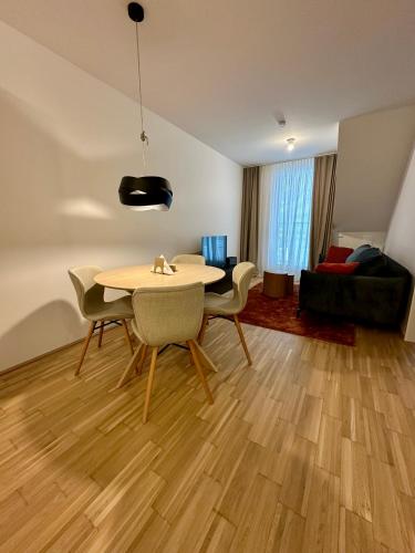a living room with a table and chairs and a couch at COHO City Apartments mit hauseigener Tiefgarage in Vienna