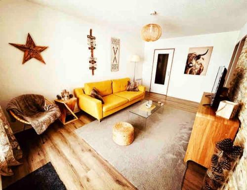 un salon avec un canapé jaune et une table dans l'établissement Superbe F3 au pied des pistes avec Piscine chauffée, à Métabief
