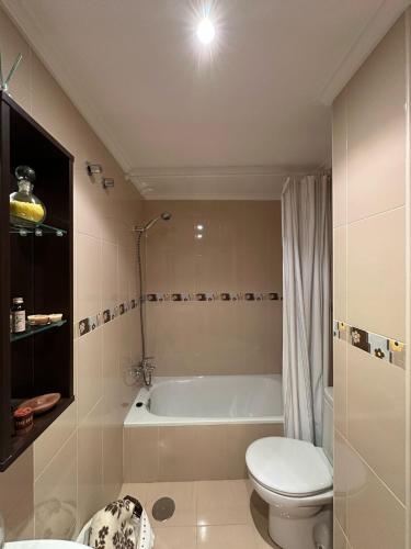 a bathroom with a toilet and a bath tub at Cuevas del Mar in Nueva de Llanes