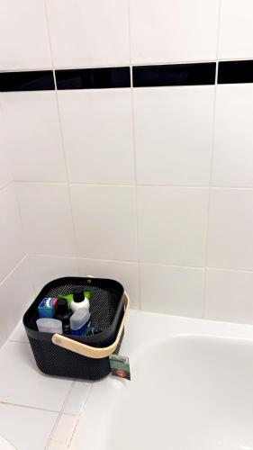 a black basket on the floor of a bathroom at Gravesend Guest Retreat in Gravesend
