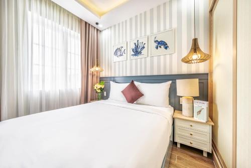 a bedroom with a large white bed and a window at DT Retreat - Biệt thự nguyên căn - 3 Phòng ngủ - Novaworld Phan Thiết in Phan Thiet