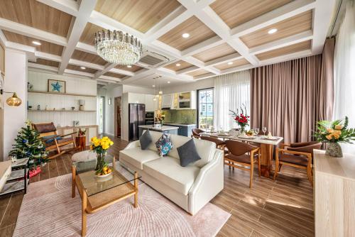 a living room with a couch and a dining room at DT Retreat - Biệt thự nguyên căn - 3 Phòng ngủ - Novaworld Phan Thiết in Phan Thiet