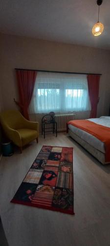 a bedroom with a bed and a rug on the floor at Gökçen Çiftliği Pansiyon in Eceabat