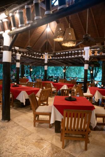 a restaurant with tables and chairs with red table cloth at Platon Ecolodge in Santa Cruz de Barahona