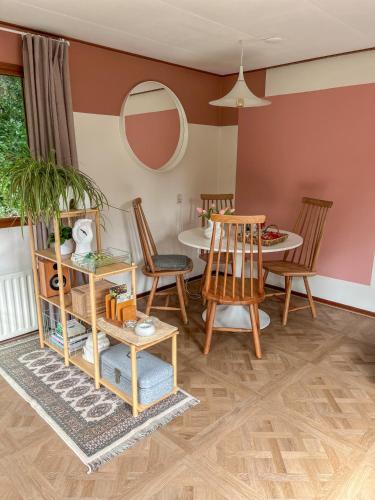 a living room with a table and chairs at Uniek boshuisje Olijfje met omheinde tuin op loopafstand Veluwse bos in Putten