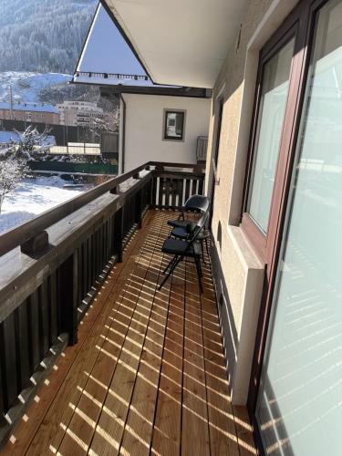 a balcony with a chair and a window at Bergblick Appartements in Bad Gastein