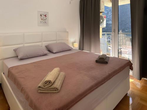 a bedroom with a bed with two towels on it at Lavander Bay E04 in Donji Morinj