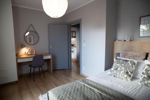 a bedroom with a bed and a desk and a chair at 4jeziora - prywatny dostęp do rzeki, pomost, ogrodem, wiata grillowa, rowerek wodny, kajaki w cenie, parking, psiaki dozwolone in Iława
