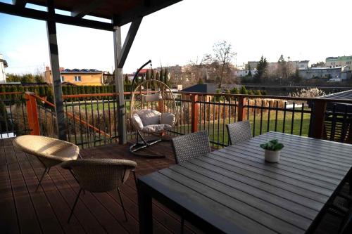 a patio with a table and chairs and a swing at 4jeziora - prywatny dostęp do rzeki, pomost, ogrodem, wiata grillowa, rowerek wodny, kajaki w cenie, parking, psiaki dozwolone in Iława