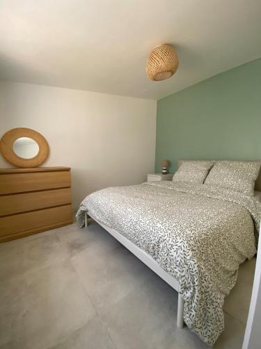 une chambre avec un lit, une commode et un miroir dans l'établissement T2 cosy avec terrasse - 5 min des plages, à La Garde