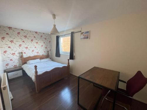 a bedroom with a bed and a table in it at 3br-Sleeps5-Balcony-CentralLondon-WS95 in London