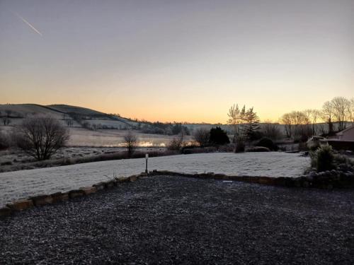 a snow covered field with the sunset in the background at Bella May Mobile Home in Ballintra