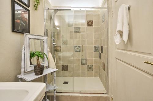 a bathroom with a shower with a sink and a mirror at Il Giardino del Cardinale - Deb'S Monticchiello in Monticchiello